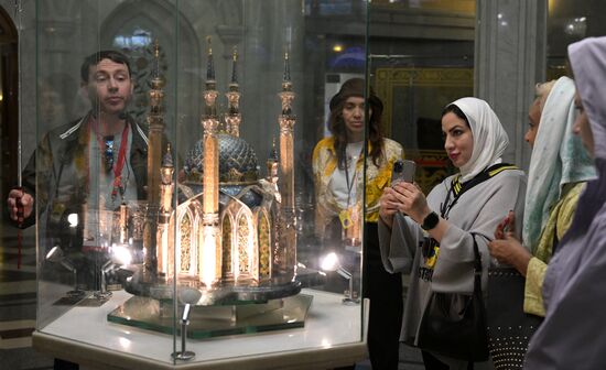 Guests of the forum take pictures of the model of the Kul Sharif Mosque on the ground floor of the Kul Sharif Mosque in the Kazan Kremlin State Historical, Architectural and Art Museum Reserve during a sightseeing tour of the city. Photos may be used as stated in the media bank section concerning the forum. Location: Russia, Republic of Tatarstan, Kazan. Author: Alexandr Kryazhev/ANO “Directorate for Sports and Social Projects”. KAZANFORUM 2023. Sightseeing tour of Kazan