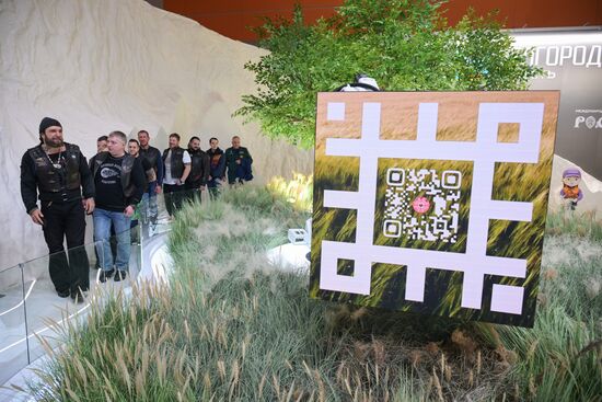 RUSSIA EXPO. Left: Night Wolves bikers' club president Alexander 'Surgeon' Zaldastanov. Right: a QR code with a link to Belgorod's VK page. Location: Russia, Moscow. Author: Vladimir Astapkovich/Sputnik. Night Wolves bikers' club president Alexander 'Surgeon' Zaldastanov visits RUSSIA EXPO