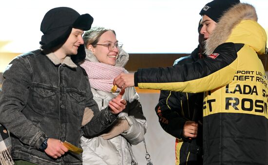 International RUSSIA EXPO forum and exhibition. Lada Granta Dream Car Lottery from Rosneft Co. and Lada Sport Rosneft Racing Team. Main outdoor stage. Right: Maxim Turiyev, driver, LADA Sport Rosneft racing team. Left: Ilya Frolikov, the main prize winner, and his girlfriend, Darya. Location: Russia, Moscow. Author: Maksim Blinov/Sputnik. RUSSIA EXPO. Lada Granta Dream Car Lottery from Rosneft Co. and Lada Sport Rosneft Racing Team