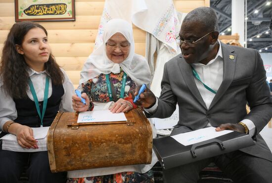 KAZANFORUM 2024. Festival of Oriental Culture organized by Kazan Federal University. Koffi Leon Konan, Charge d'Affaires of Côte d'Ivoire in the Russian Federation. A calligraphy workshop. Images can be used under terms set out in the Kazanforum section of the Media Bank. Location: Russia, Republic of Tatarstan, Kazan. Author: Alexandr Kryazhev/Sputnik. KAZANFORUM 2024. Festival of Oriental Culture by Kazan Federal University