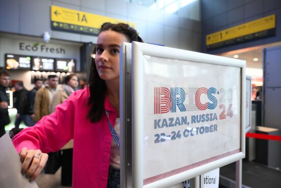 Preparations for the 16th BRICS Summit in Kazan. An airport employee puts up a summit notice. The 16th BRICS Summit will be held in Kazan on October 22-24. Location: Russia, Republic of Tatarstan, Kazan. Author: Alexandr Kryazhev. Preparations for 16th BRICS Summit in Kazan