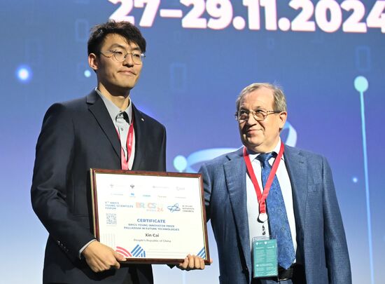 The 4th Young Scientists Congress. Plenary session. Winners of the BRICS Contest of Young Innovators announced. Award ceremony. From left: Xin Cai, innovator, China; Gennady Krasnikov, President of the Russian Academy of Sciences. Location: Russia, Federal territory 'Sirius'. Author: Ilya Pitalev. 4th Young Scientists Congress. Plenary session