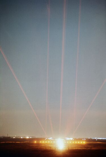 A laser beam guides an airplane to a landing