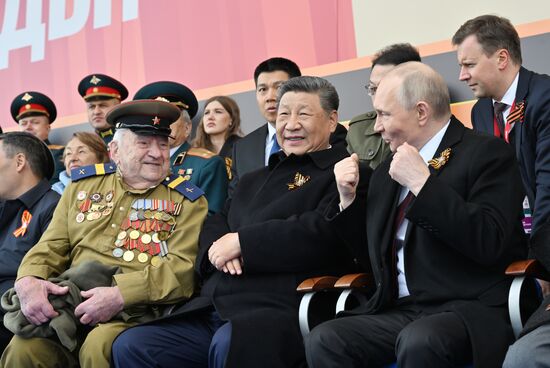 From right: President of Russia Vladimir Putin and President of China Xi Jinping on Red Square in Moscow, where a military parade marking the 80th anniversary of Victory is taking place. Russia marks the 80th anniversary of Victory in the Great Patriotic War of 1941-1945. Left: veteran of the Great Patriotic War Yevgeny Znamensky. Location: Russia, Moscow. President of Russia Vladimir Putin and foreign leaders at military parade marking 80th anniversary of Victory
