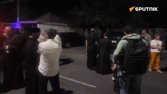 Supporters of Archbishop Mikael Ajapahian gather outside the courthouse in Yerevan where a motion for his arrest is being considered