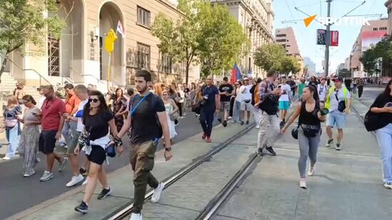 Serbian protesters march in Belgrade, waving flags